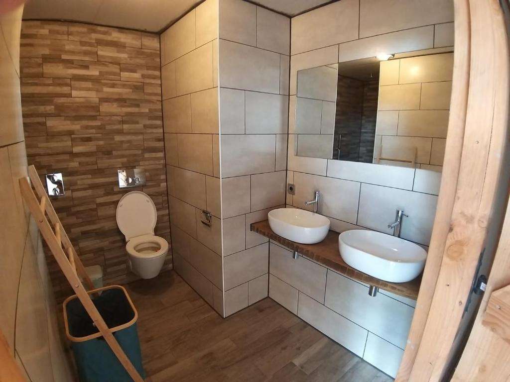 une salle de bain avec deux lavabos et un WC dans l'établissement Glamping Resort Bousset, à Chiddes
