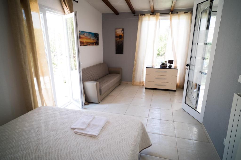 - une chambre avec un lit, un canapé et des fenêtres dans l'établissement VILLA FREEMAN, à Ostuni