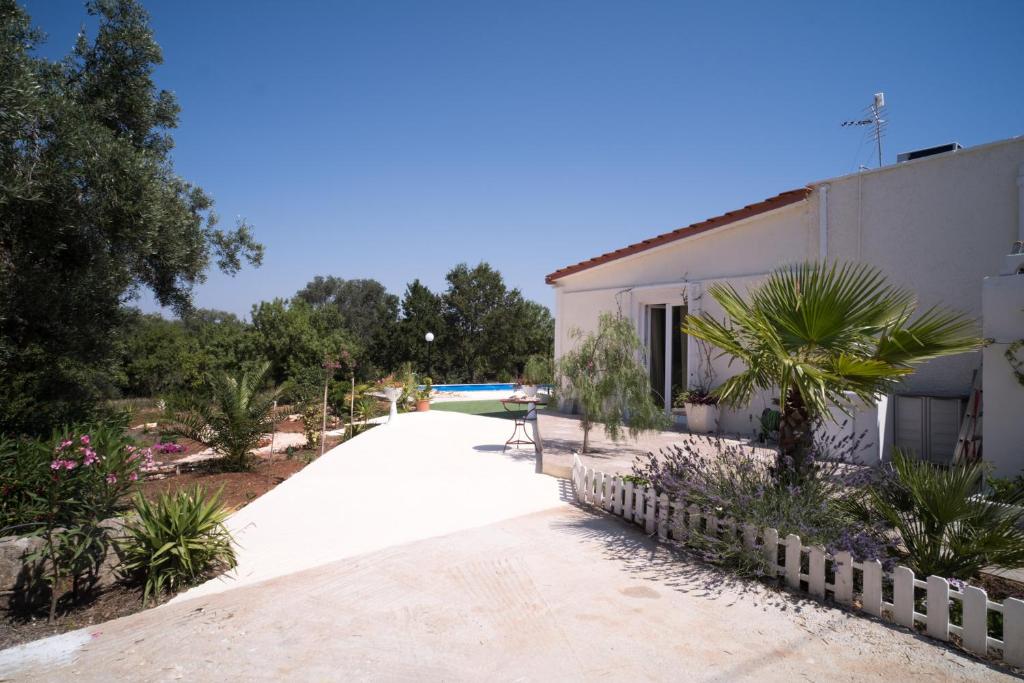 une passerelle à côté d'un bâtiment avec des arbres et des plantes dans l'établissement VILLA FREEMAN, à Ostuni
