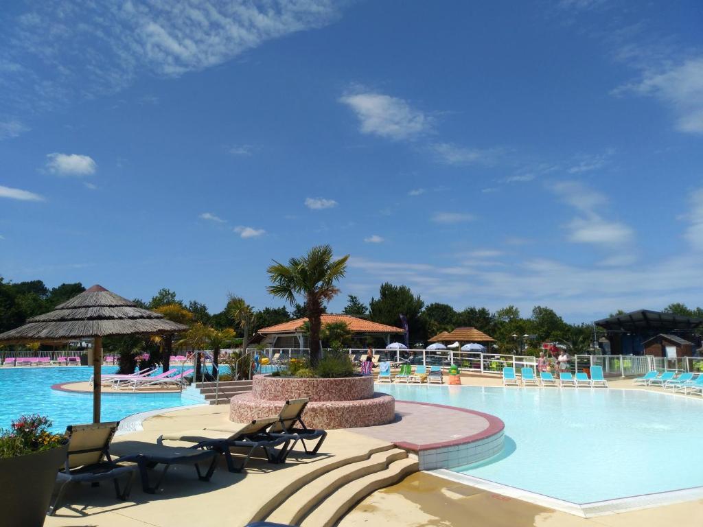 une piscine dans un complexe avec des chaises et un palmier dans l'établissement Cordon LMP, à Gastes