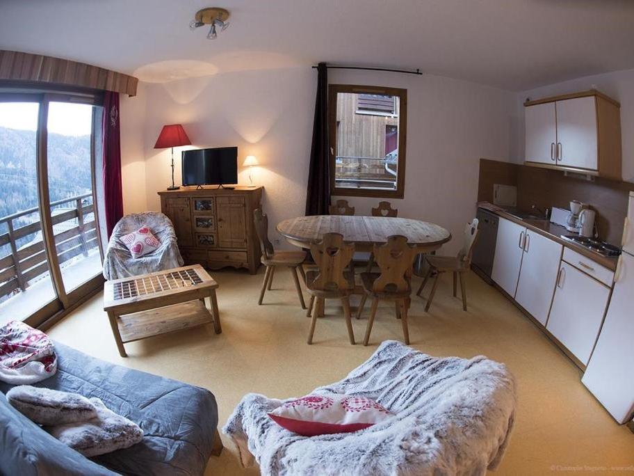 un salon avec un canapé et une table et une cuisine dans l'établissement VAUJANYLOCATIONS - Chalet De Marie, à Vaujany 16 autres photos