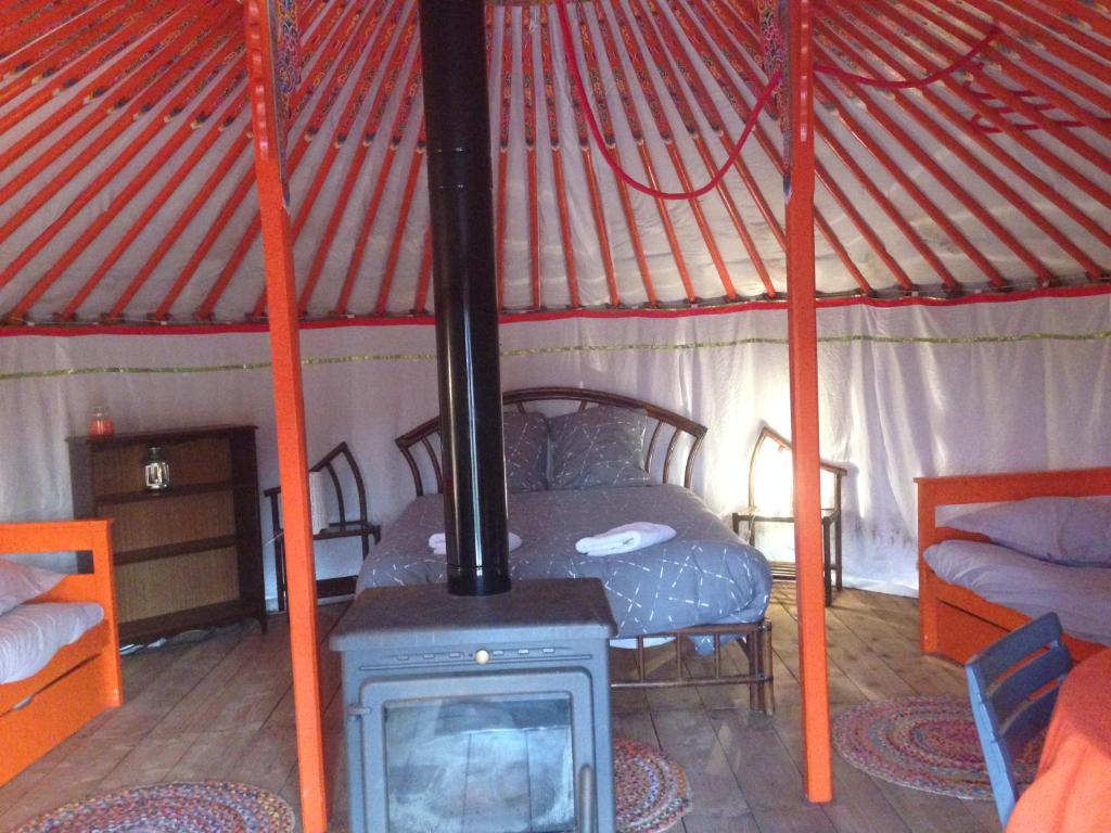 Cette chambre comprend une cuisinière et un lit dans une yourte. dans l'établissement Yourte Mongole, à Saint-Léger-sur-Dheune