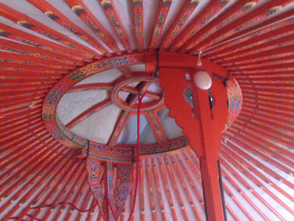 un plafond rouge avec une horloge rouge dans l'établissement Yourte Mongole, à Saint-Léger-sur-Dheune