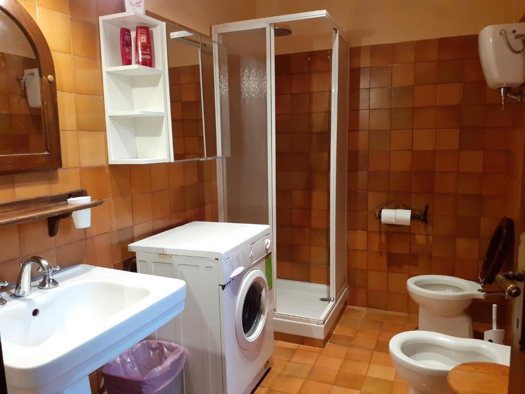 une salle de bain avec une machine à laver et un lavabo dans l'établissement Villa con Piscina in Umbria, à Foligno