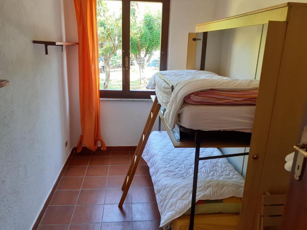 une petite chambre avec deux lits superposés et une fenêtre dans l'établissement Villa con Piscina in Umbria, à Foligno