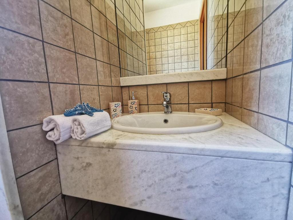 une salle de bain avec un lavabo et un miroir dans l'établissement Villa Arenile - Seaside - Swimmingpool- Private access to Sea - waterfront - Fontane Bianche - Siracusa, à Fontane Bianche