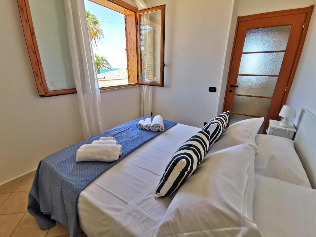 - une chambre avec un lit, des serviettes et une fenêtre dans l'établissement Villa Arenile - Seaside - Swimmingpool- Private access to Sea - waterfront - Fontane Bianche - Siracusa, à Fontane Bianche 74 autres photos