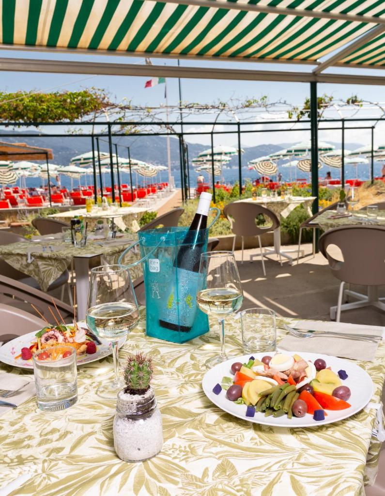 - une table avec une assiette de nourriture et une bouteille de vin dans l'établissement Regina Elena Dependance, à Santa Margherita Ligure