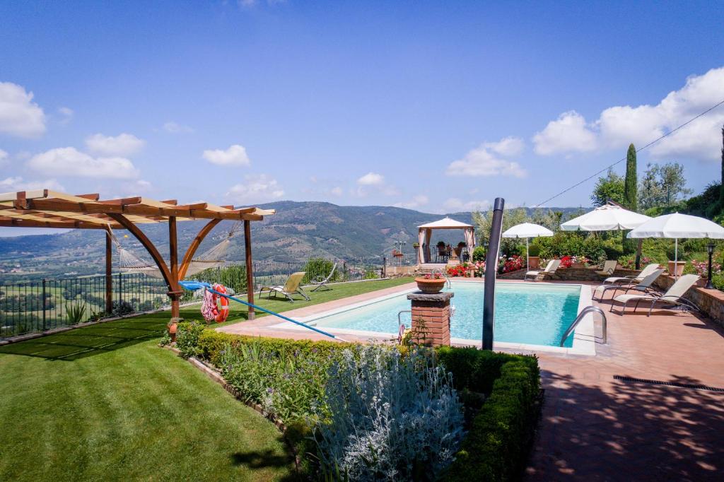 - une piscine dans une cour avec vue sur les montagnes dans l'établissement Agriturismo Fonte Vinaglia, à Castiglion Fiorentino