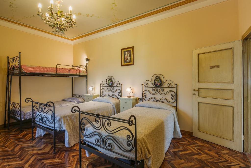 - une chambre avec 3 lits et une porte dans l'établissement Agriturismo Fonte Vinaglia, à Castiglion Fiorentino