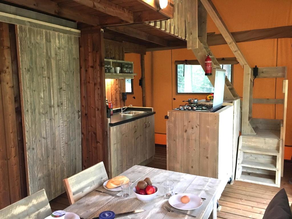 une cuisine avec une table avec un bol de fruits dessus dans l'établissement Safaritent Glamping L'Ardechois, à Gluiras
