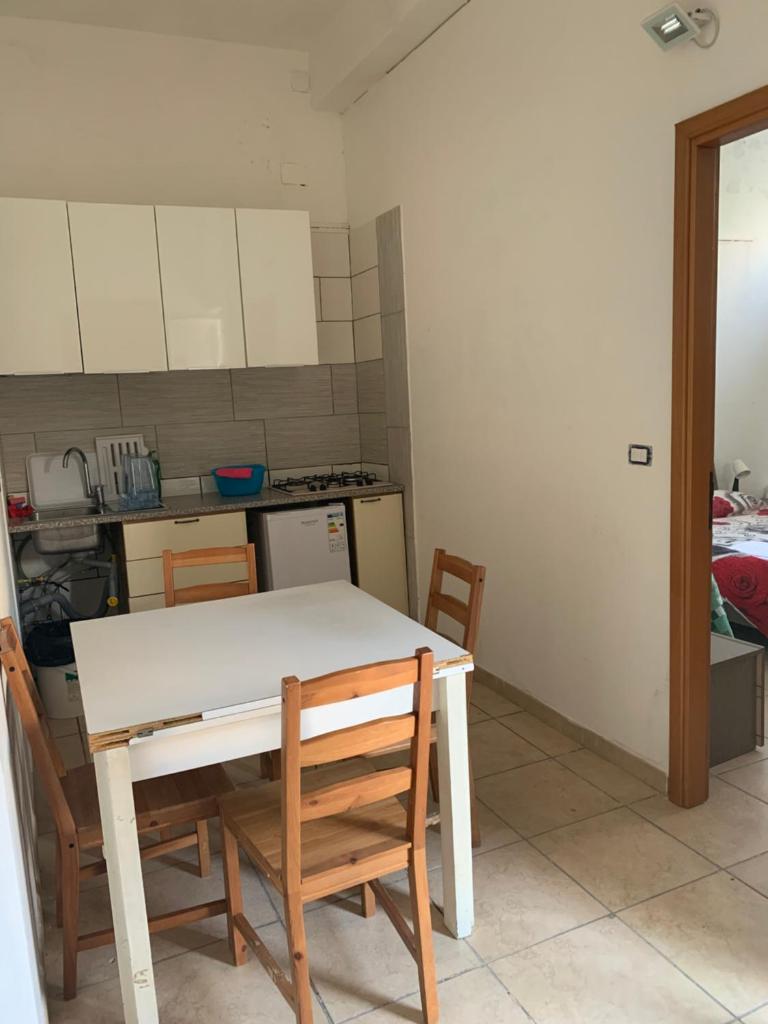 - une cuisine avec une table et des chaises blanches dans la chambre dans l'établissement Villa belvedere mini appartamento, à Pontecagnano