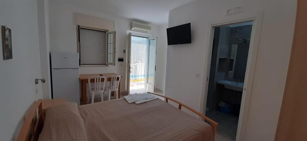 une petite chambre avec un lit et une cuisine dans l'établissement Residence Adriatico, à Mattinata