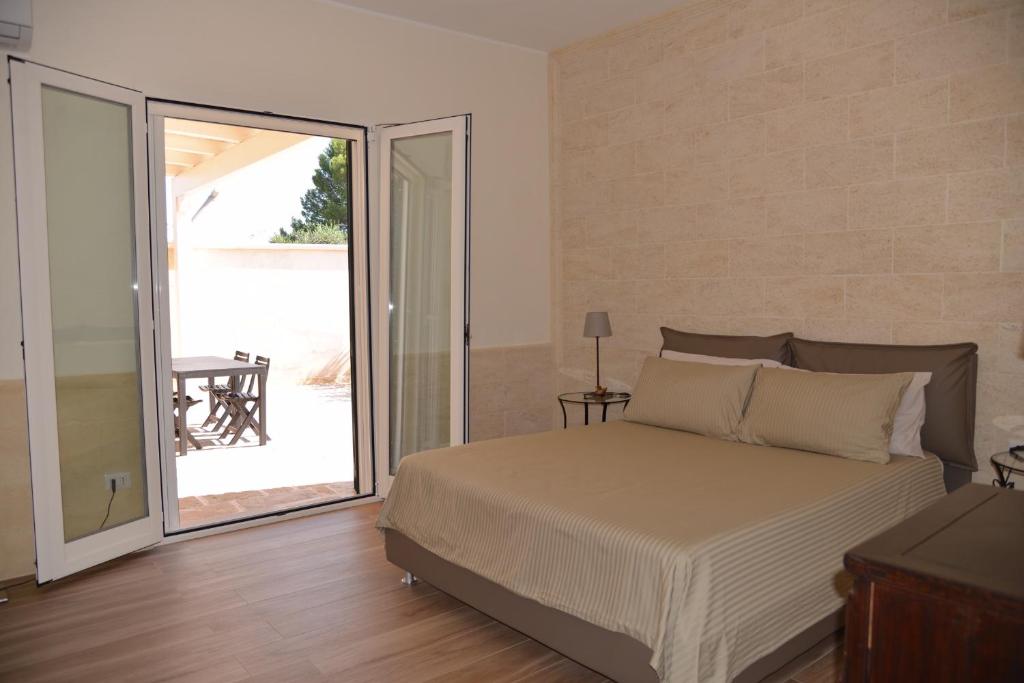une chambre avec un lit et une porte coulissante en verre dans l'établissement Corte del Sole, à Mandurie 55 autres photos