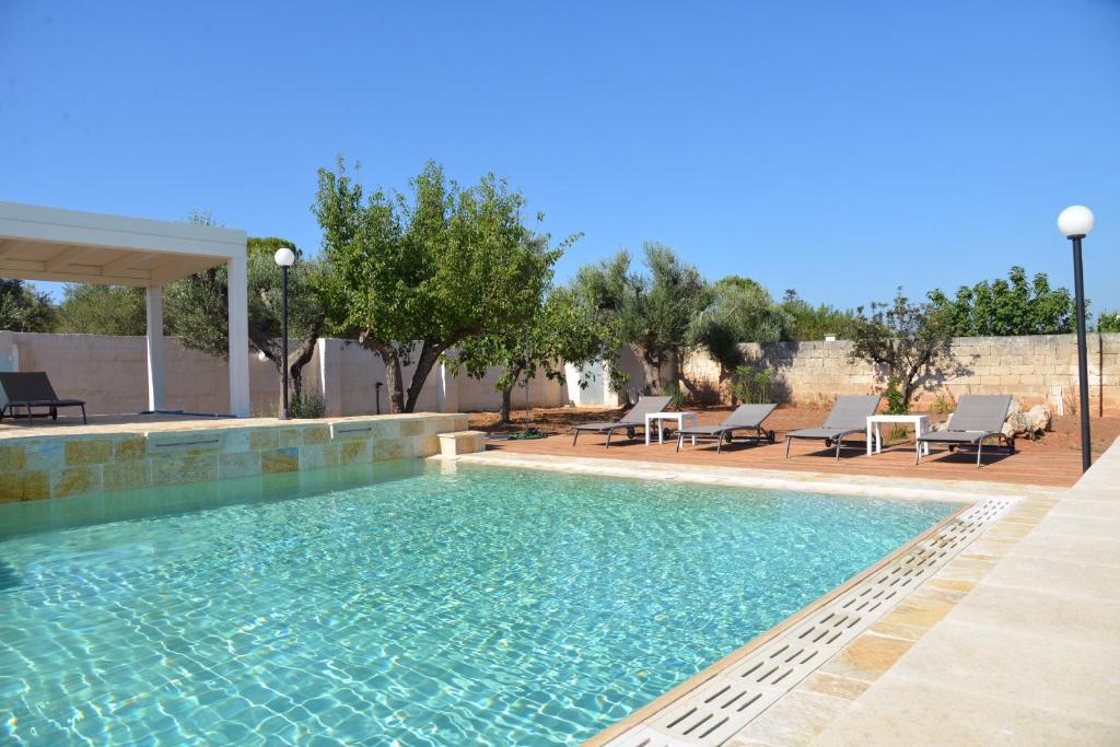 - une piscine dans une cour avec des chaises et des arbres dans l'établissement Corte del Sole, à Mandurie