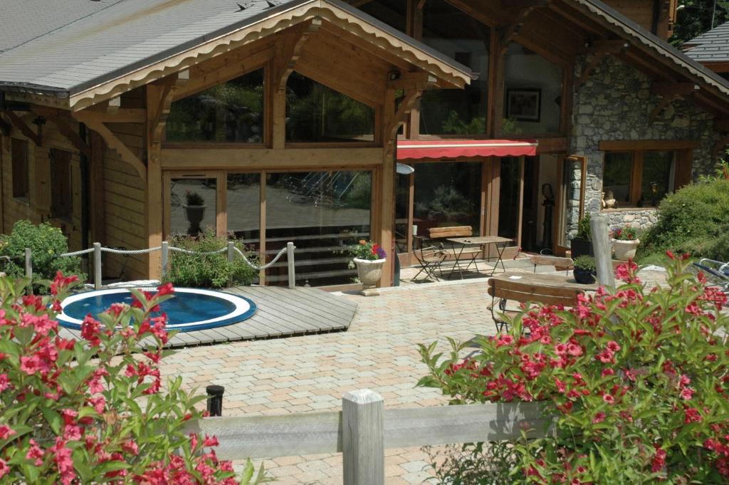 une maison avec une terrasse et une piscine dans l'établissement Hôtel et Chalet Au Coin Du Feu Chilly Powder, à Morzine