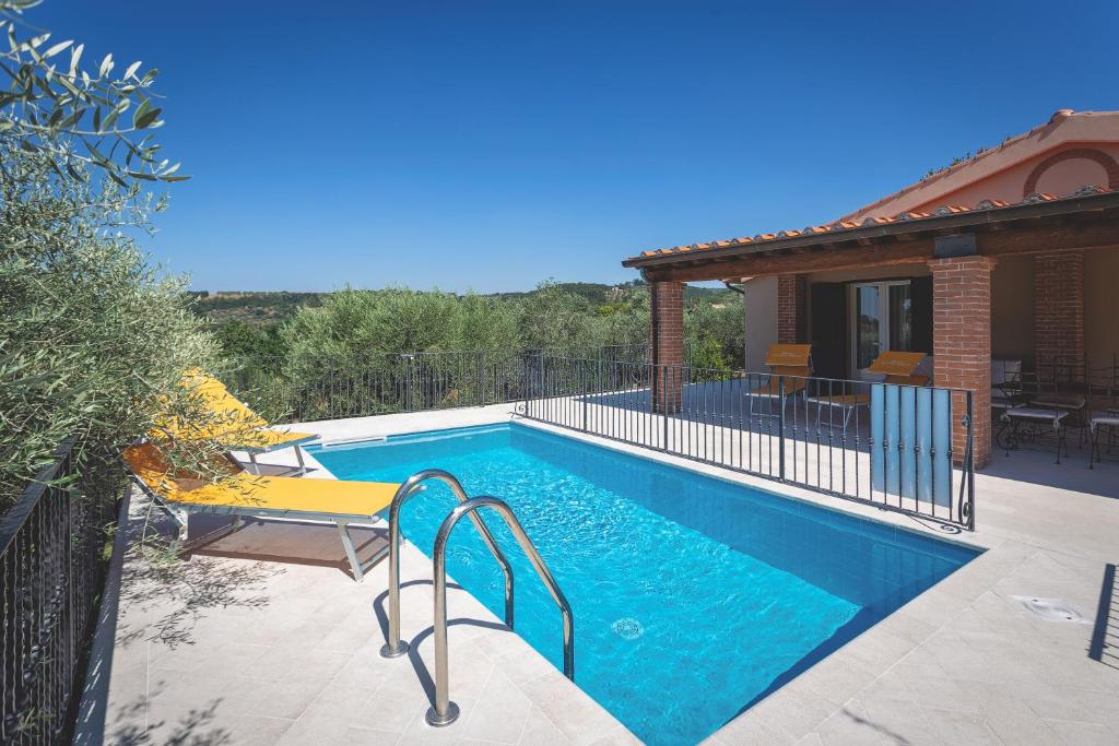 une piscine dans une cour avec une maison dans l'établissement Cottage Zizzolo, à Riparbella