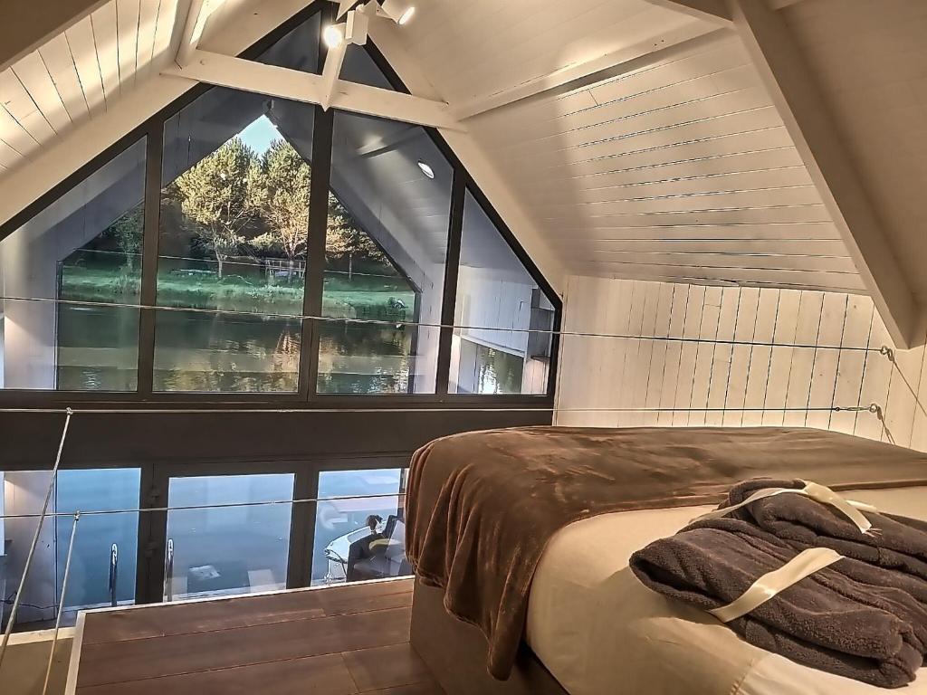 une chambre avec un lit et une grande fenêtre dans l'établissement Les Kabanes de Kerforn, à Crach