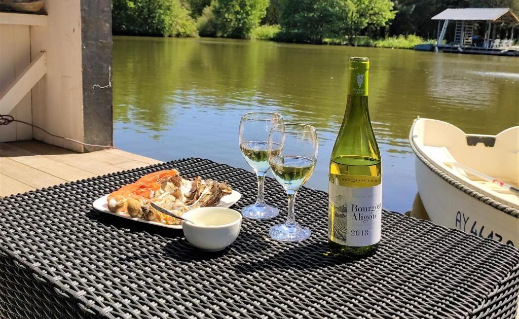 - une table avec deux verres de vin et une assiette de nourriture dans l'établissement Les Kabanes de Kerforn, à Crach 22 autres photos