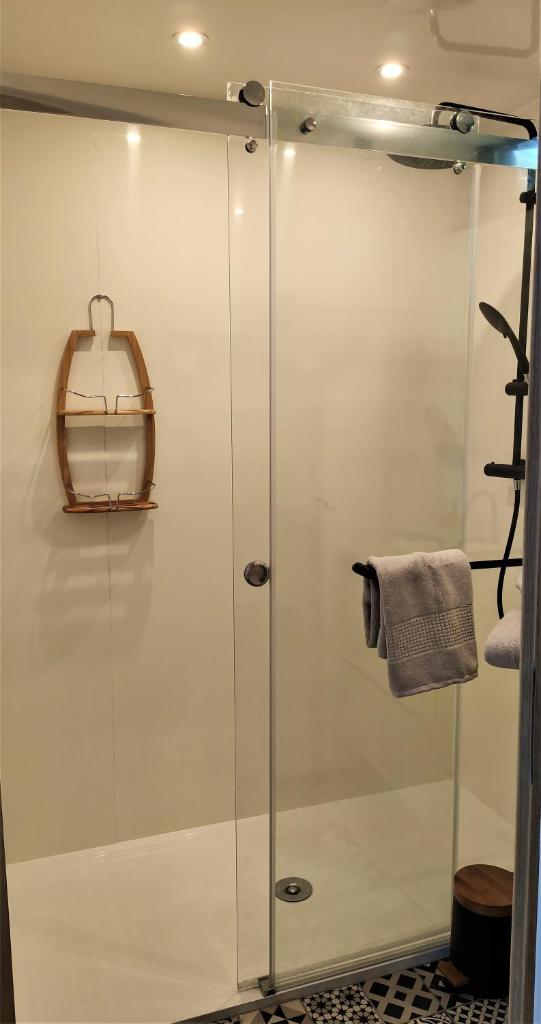 une douche avec une porte vitrée dans une salle de bain dans l'établissement Les Kabanes de Kerforn, à Crach