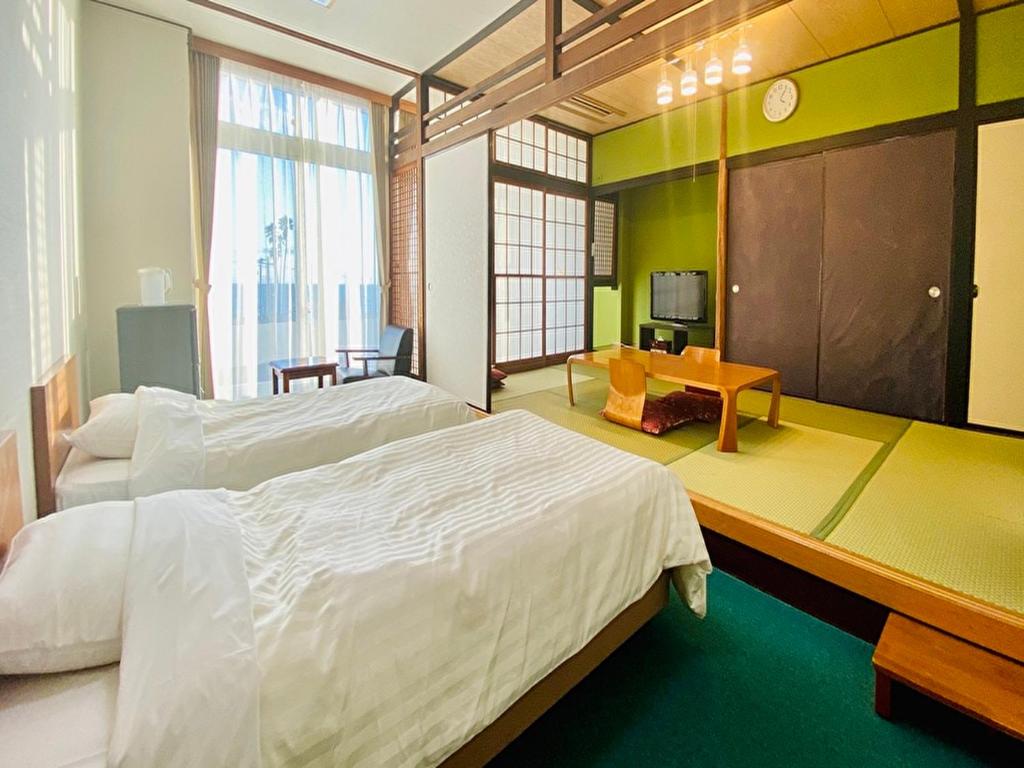 une chambre avec un grand lit blanc et un bureau dans l'établissement Nangoku Hotel, à Minamiboso 50 autres photos