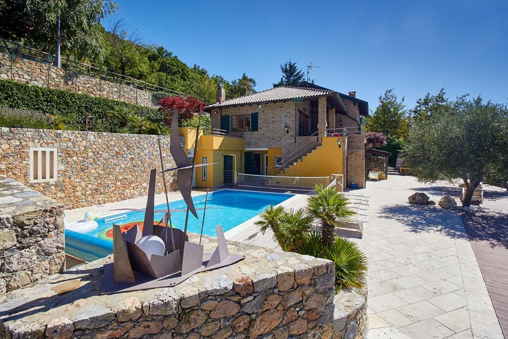 une villa avec piscine devant une maison dans l'établissement Rivierarent Villa Pina, à Magliolo