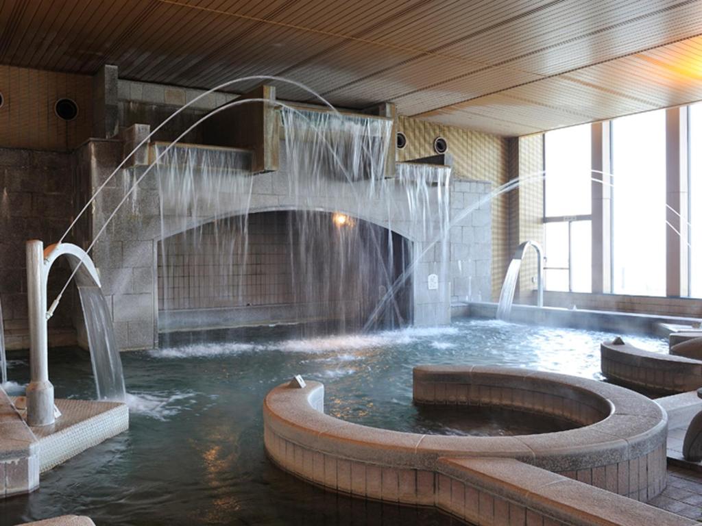 - une piscine avec une fontaine dans un bâtiment dans l'établissement Ryugujo Spa Hotel Mikazuki Ryugutei, à Kisarazu