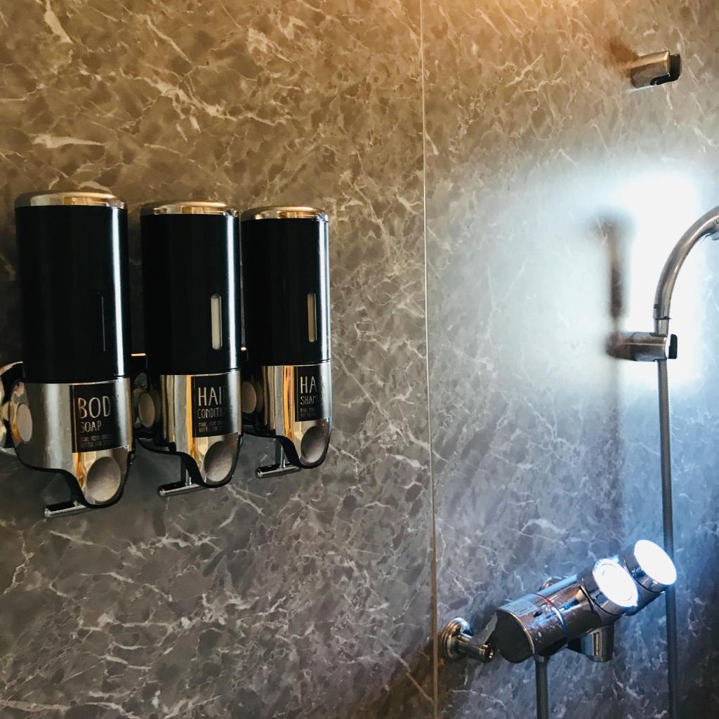 une salle de bain avec une douche avec un lavabo et un miroir dans l'établissement Shirahama no Yado Daigo, à Shirahama 37 autres photos