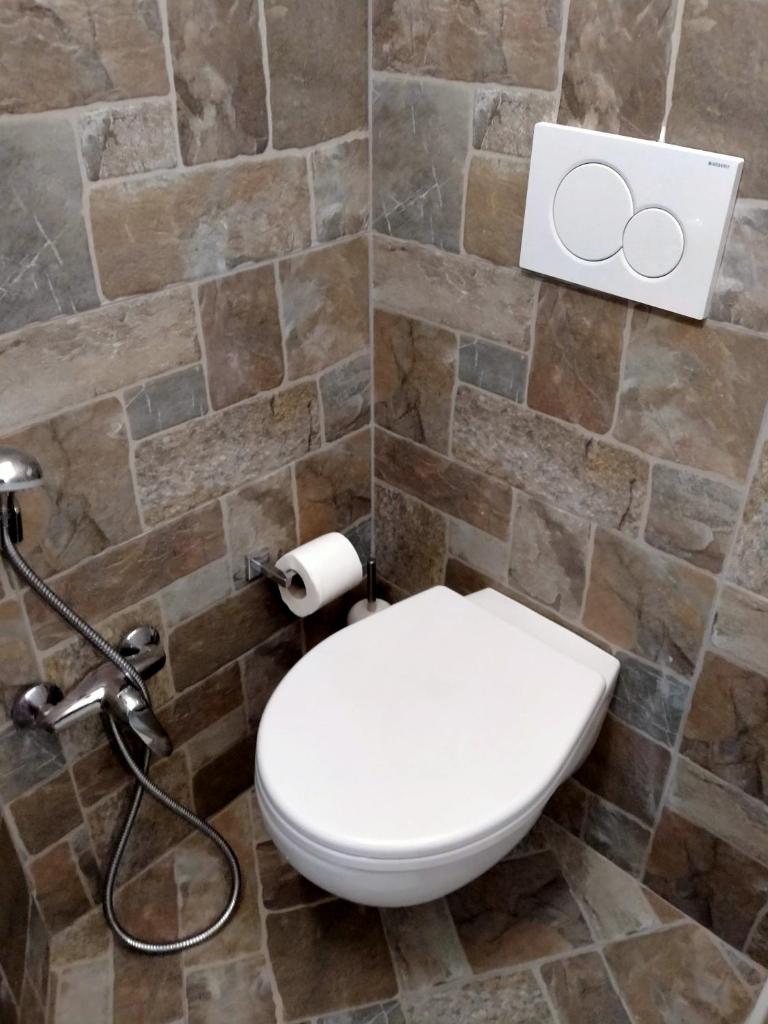 La salle de bains est pourvue de toilettes et d'un mur en pierre. dans l'établissement Hotel Ristorante Miramare, à Pesaro 46 autres photos