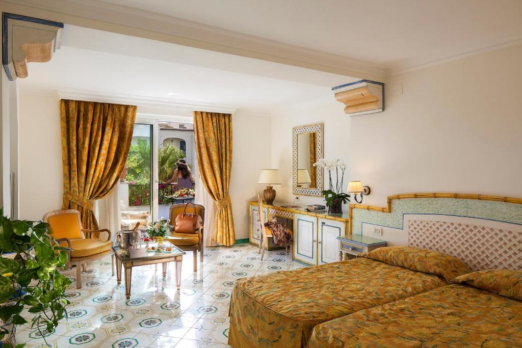 une chambre avec un lit et un salon dans l'établissement Grand Hotel Il Moresco, à Ischia