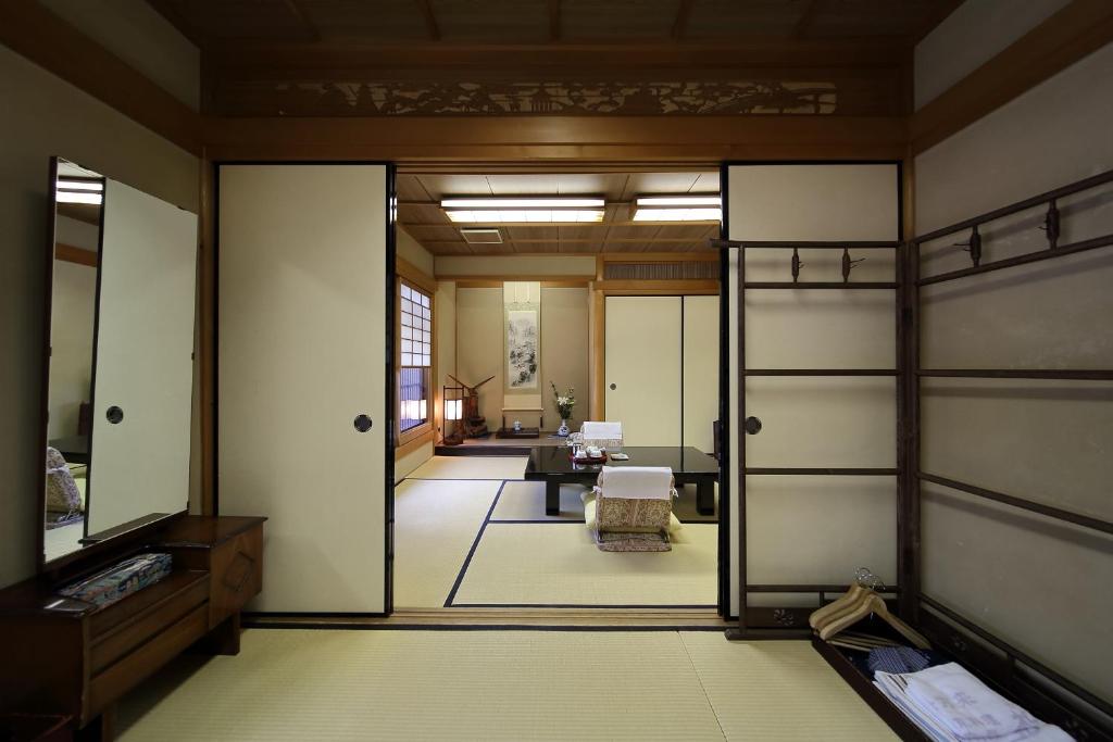 une chambre avec une porte s'ouvrant sur un salon dans l'établissement Yadoya Kikokuso, à Kyoto