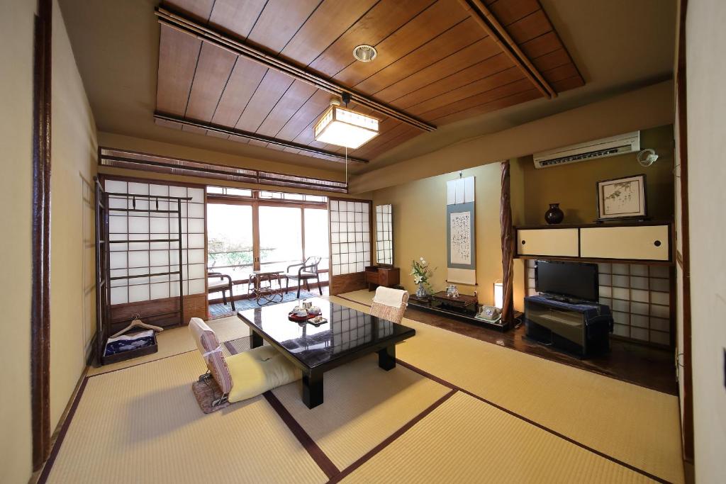 un grand salon avec une table et un canapé dans l'établissement Yadoya Kikokuso, à Kyoto