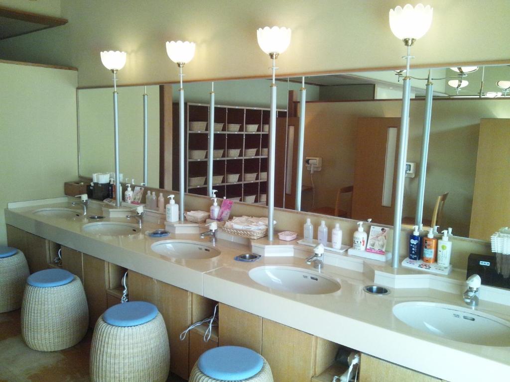 La salle de bains est pourvue de 3 lavabos et d'un grand miroir. dans l'établissement Hirugami Grand Hotel Tenshin, à Achi 31 autres photos