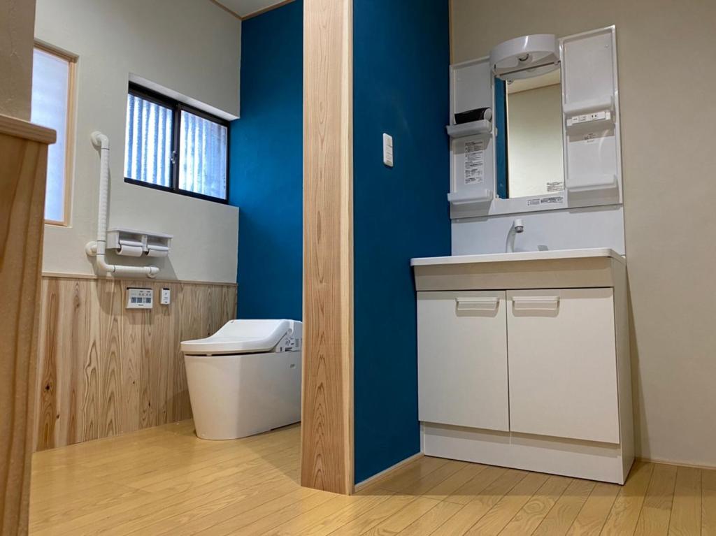 une salle de bain avec toilettes et un mur bleu dans l'établissement Riverside Hotel Karatsu Castle, à Karatsu 37 autres photos
