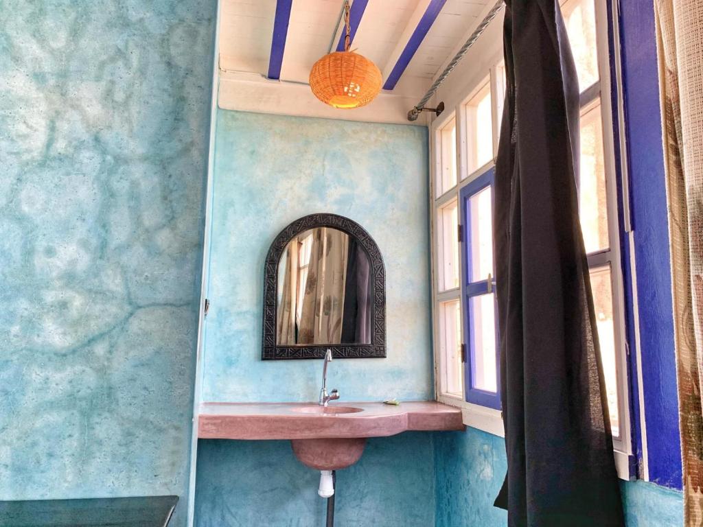 une salle de bain avec un lavabo et un miroir dans l'établissement Riad Beldy, à Essaouira 37 autres photos