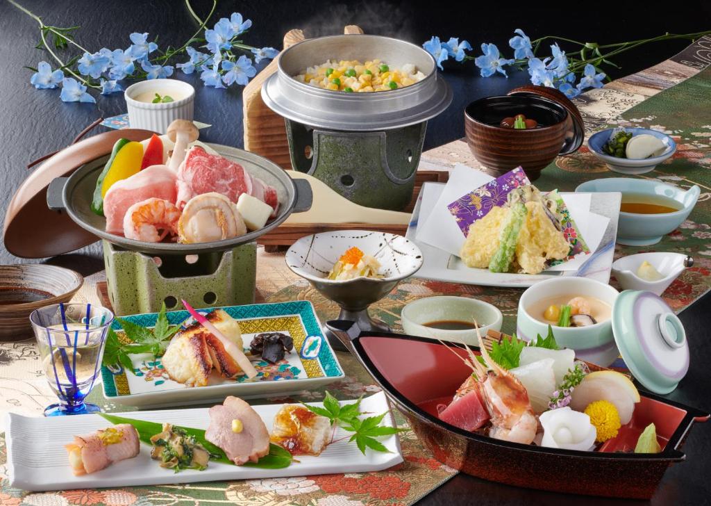 une table avec de nombreuses assiettes de nourriture dessus dans l'établissement Awazuonsen Kitahachi, à Komatsu