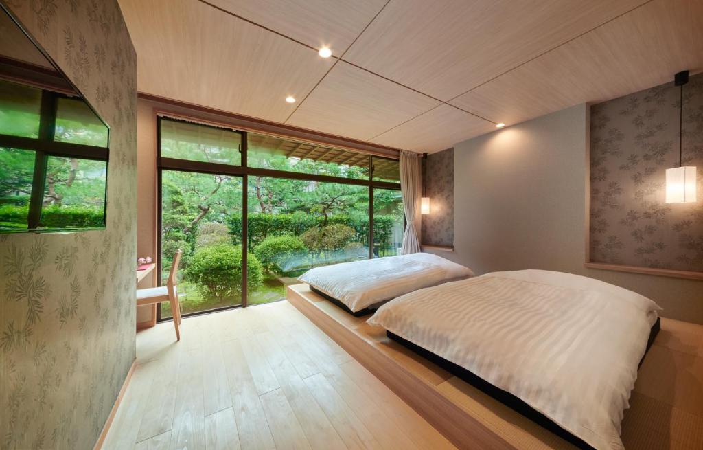 une chambre avec un lit et une grande fenêtre dans l'établissement Awazuonsen Kitahachi, à Komatsu 37 autres photos