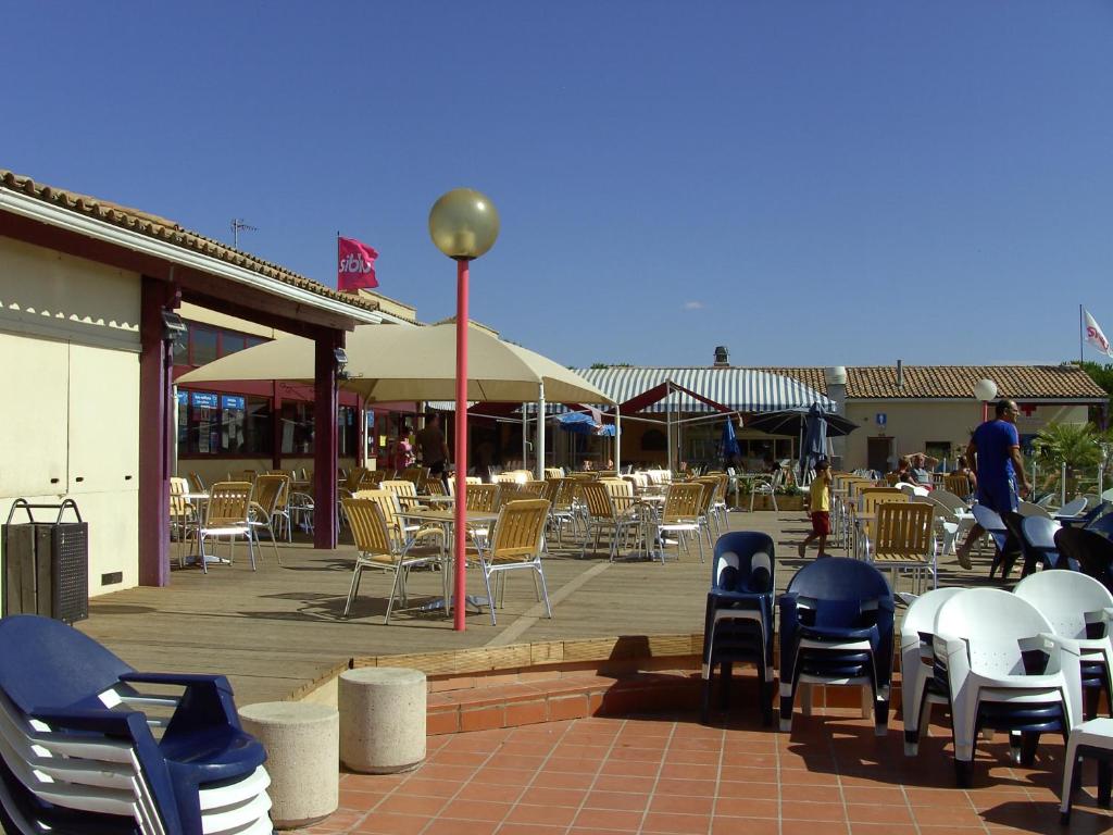 - un ensemble de chaises, de tables et de chaises sur une terrasse dans l'établissement MOBIL HOME 3ch 2sdb A LATTES, à Lattes