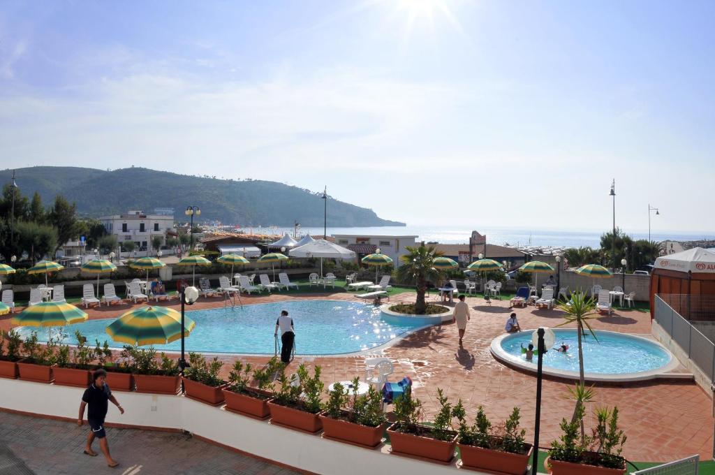 un complexe avec une piscine et des gens qui se promènent autour dans l'établissement Morcavallo Hotel & Wellness, à Peschici