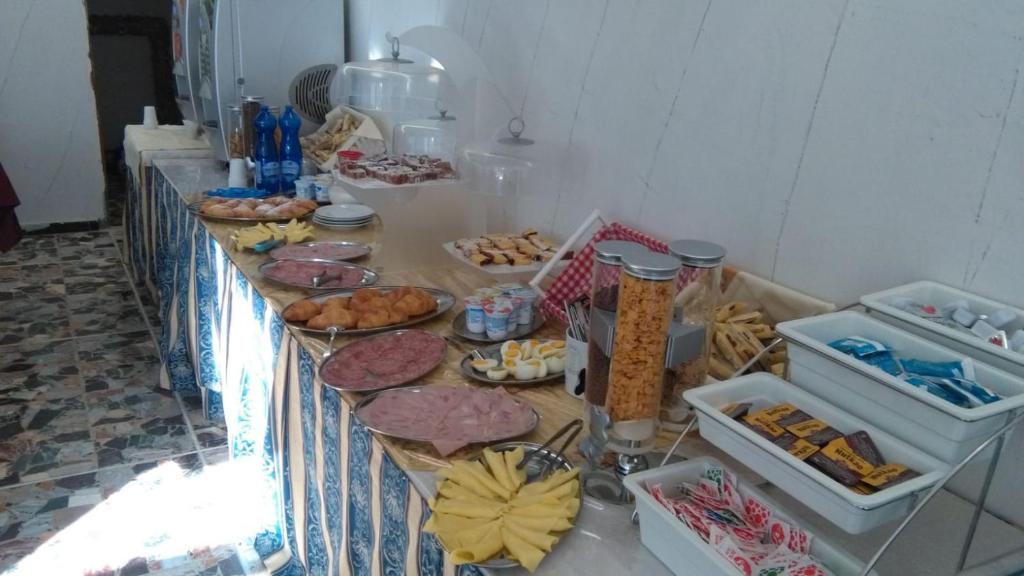 une longue table remplie de différents types de nourriture dans l'établissement Hotel Lexington, à Rimini