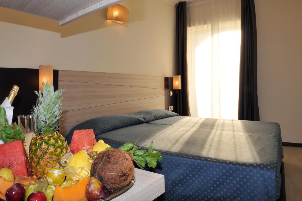 - une chambre avec un lit et une corbeille de fruits sur une table dans l'établissement Morcavallo Hotel & Wellness, à Peschici