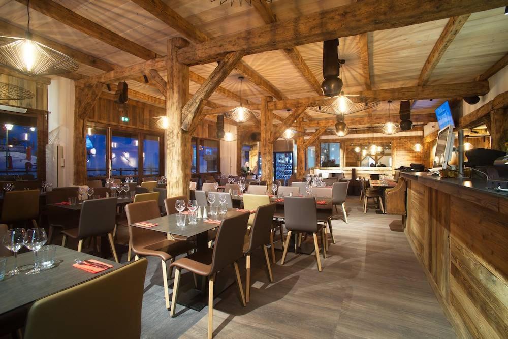 un restaurant avec des tables et des chaises dans une salle dans l'établissement Studio 4 personnes au pied des pistes. Le Corbier, au Corbier