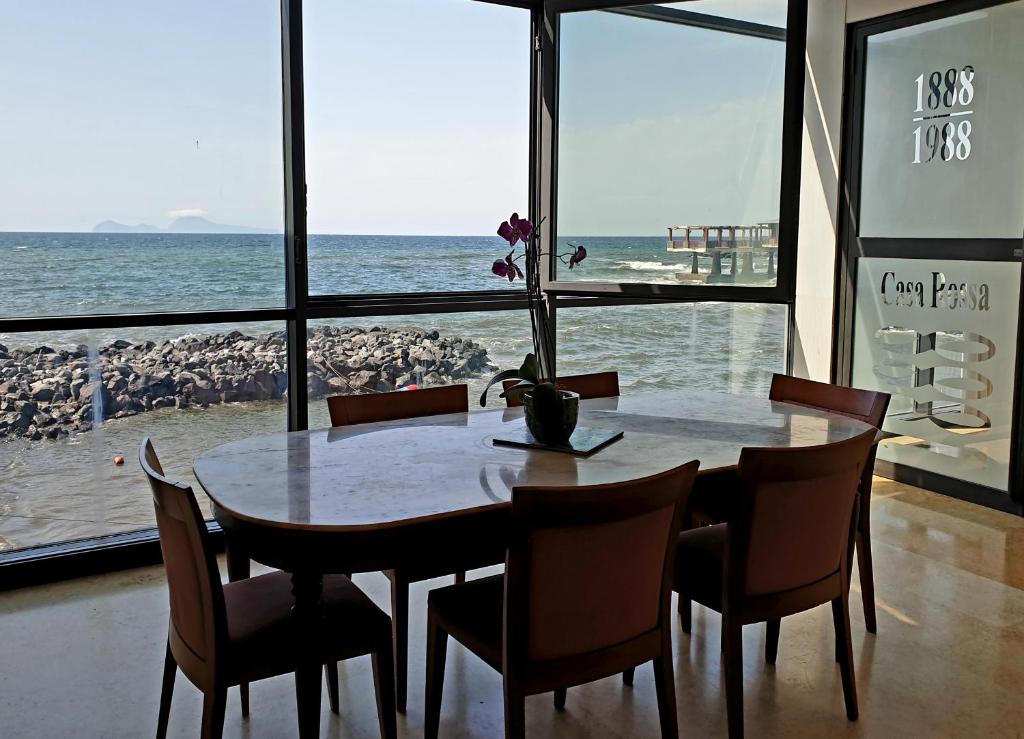 une table et des chaises avec vue sur l'océan dans l'établissement Casa Rossa 1888, à Torre del Greco