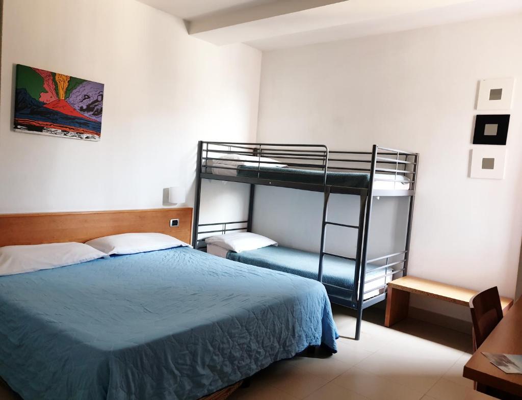 une chambre avec un lit et un lit superposé dans l'établissement Casa Rossa 1888, à Torre del Greco