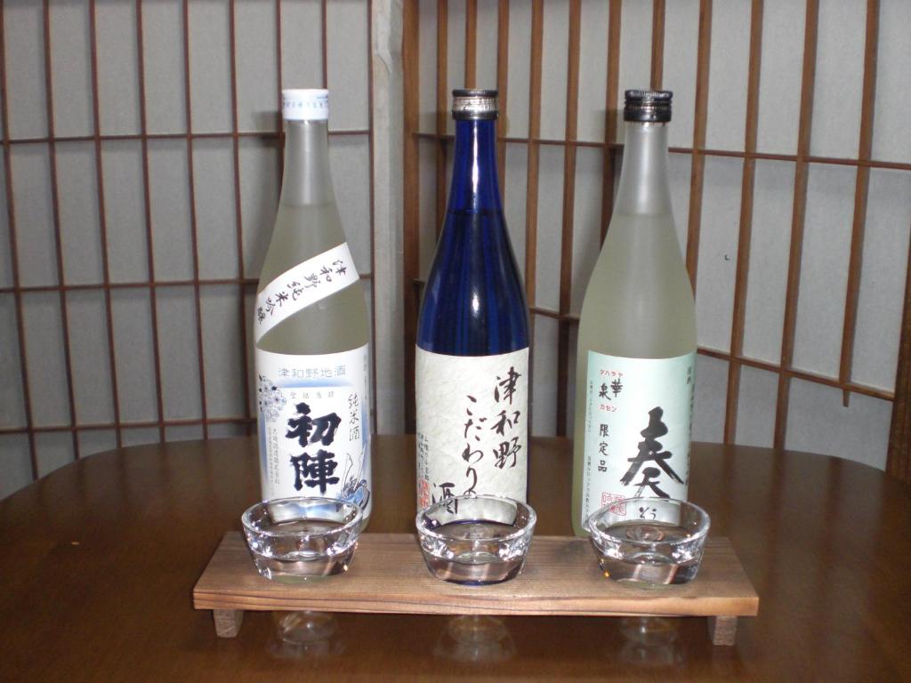 trois bouteilles de vin assises sur une table en bois dans l'établissement Hoshi Ryokan, à Tsuwano