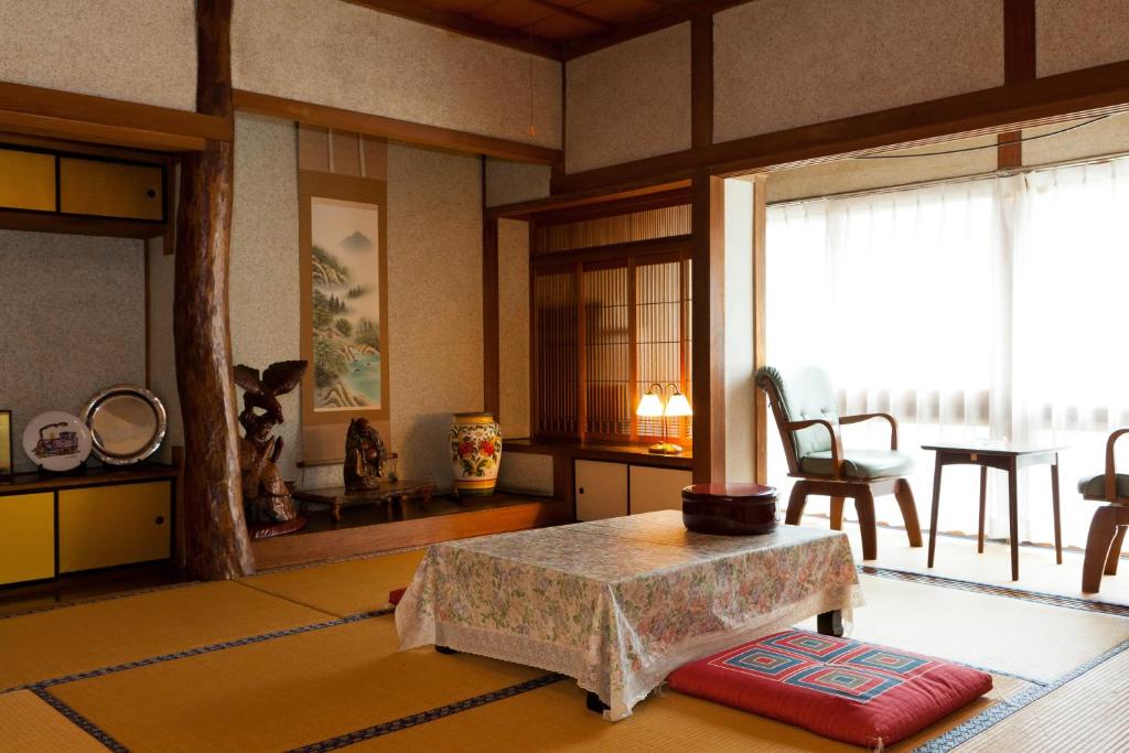 Cette chambre comprend un salon avec une table et une fenêtre. dans l'établissement Hoshi Ryokan, à Tsuwano