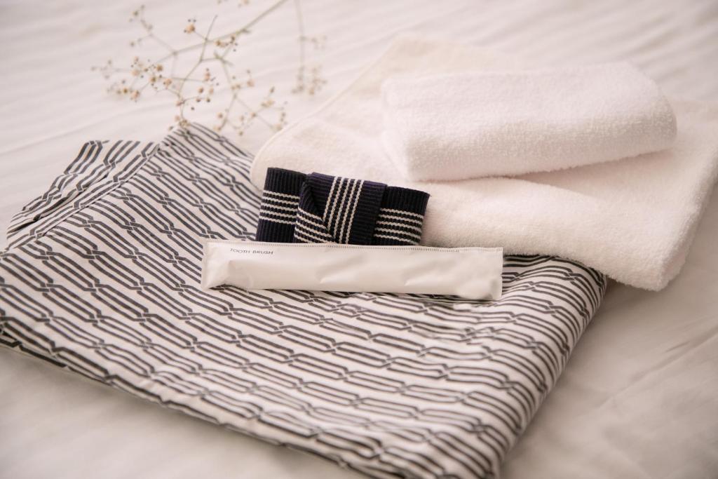- une pile de serviettes et de serviettes sur un lit dans l'établissement Omuta Heights, à Ōmuta