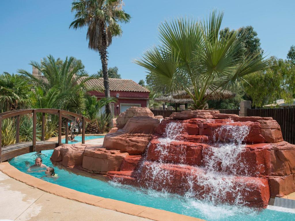 - un toboggan dans une piscine avec cascade dans l'établissement Camping Les Palmiers, à Hyères
