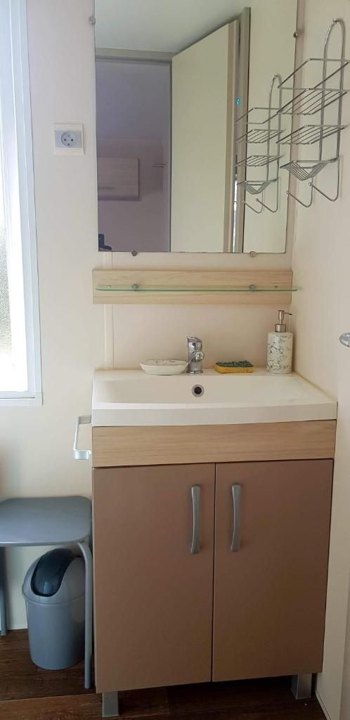 une salle de bain avec un lavabo et un miroir dans l'établissement omaha beach home, à Colleville-sur-Mer