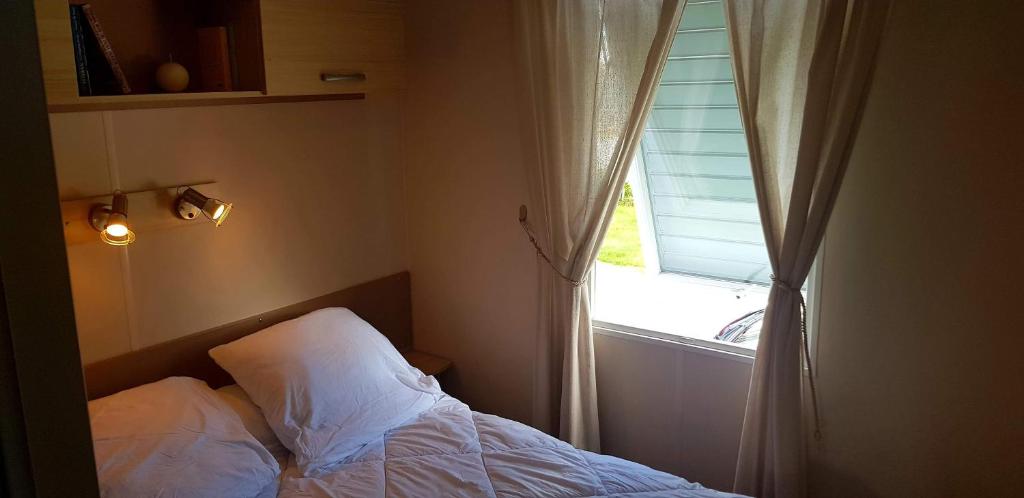 une chambre avec un lit et une fenêtre dans l'établissement omaha beach home, à Colleville-sur-Mer